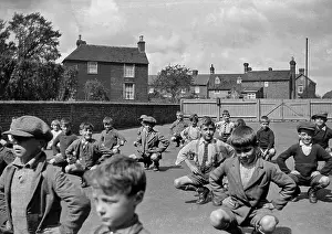 Squat: Boys exercising in school playground