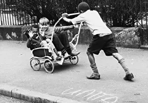 Boys playing with an old pram frame