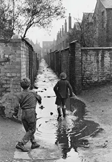 Puddle: Boys playing in a puddle in an alleyway