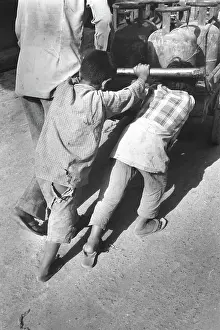 Toil: Boys push loaded cart