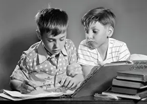 Schoolbooks: Two Boys with Schoolbooks and Papers Studying Together In
