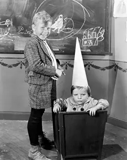 Blackboards: Two boys, one wearing a dunce's cap