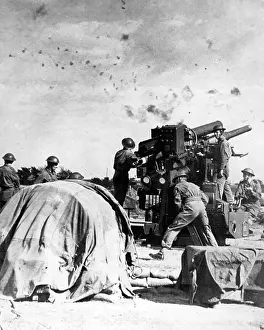 Mounting: British gunners at work beneath a flak-filled sky, WW2