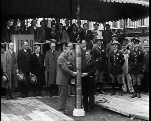 Lowered: Two British Men Guiding a Time Capsule Being