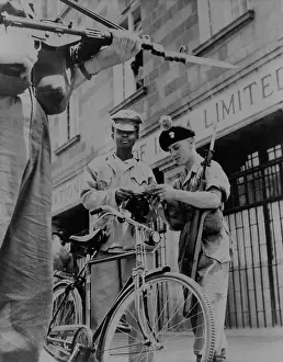 Intern: British soldiers examining papers of an African
