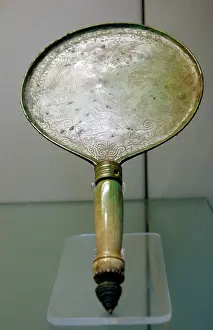 Showcase: Bronze mirror with bone handle engraved with a scene depicti