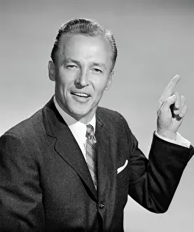 Emphatic: Business man pointing with left hand quizzical
