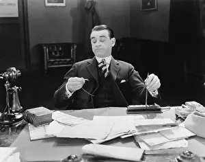 Professionals: Businessman at desk looking at watch