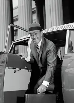 Checker: Businessman holding briefcase getting out of