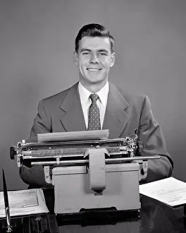 Laboring: Businessman Seated at Typewriter Smiling Looking