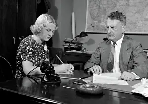 Shorthand: Businessman sitting at desk going over paperwork