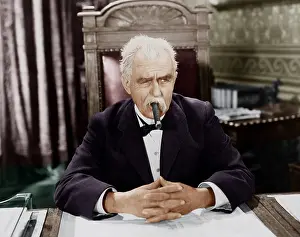 Skeptic: Businessman smoking cigar at desk