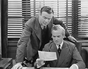 Perplexed: Two businessmen with an inter office memo