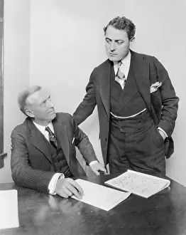 Cooperate: Two businessmen in an office having a discussion