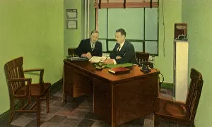 Pore: Two businessmen sit at a desk