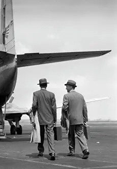 Briefcases: Two businessmen walking towards a Martin 4-0-4 plane