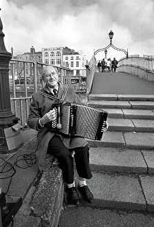 Busking: Busker plays an accordian on Ha'penny Bridge, Dublin