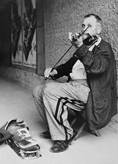 Busker: Busker with violin in Vienna. About 1960