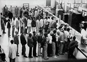 Influx: c. 1980. Men queue for passes at Albert Street