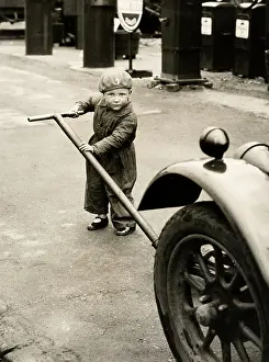 Gelatin: c.1920's - small child in overalls jacking up a car