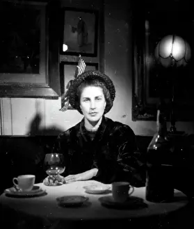 Brandy: Carly in a hat in a dark cafe