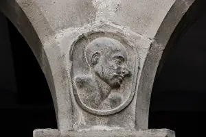 Understood: Carved figures of pupils, between the arches of the patio
