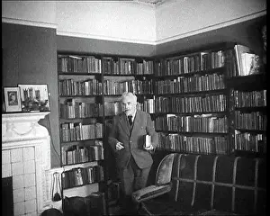 Joad: C.E.M Joad Taking Some Books to His Desk