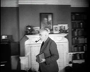 Joad: C.E.M Joad Taking Some Books to His Desk