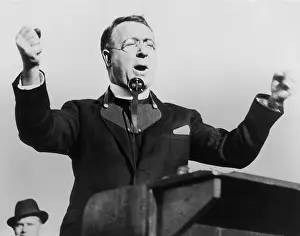 Coughlin: Charles Coughlin, with fists raised, attacks the