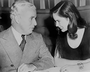 Oona: Charlie Chaplin (1889-1977) sitting with ?