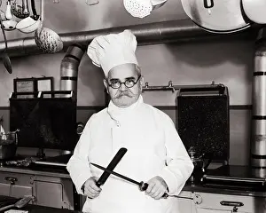 Slicing: Serious Chef Man Wearing Toque Standing in Professional
