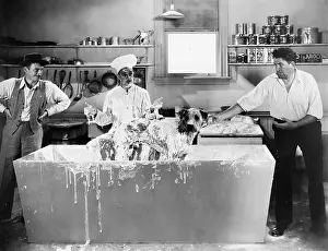 Suds: Chef and men wash a dog in the kitchen