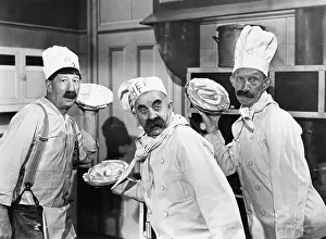 Mustaches: Three chefs holding pies for a fight in the kitchen
