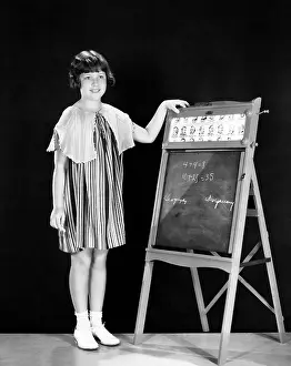 Sums: Child doing mathematics exercises on blackboard