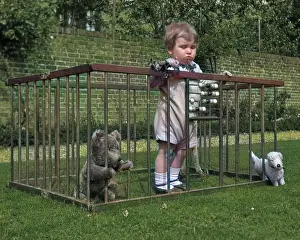 Flowerbed: Child in a playpen in a garden