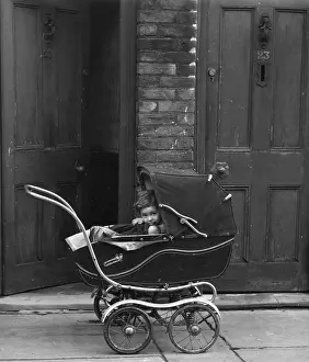 Terraced: Child in a pram outside a house