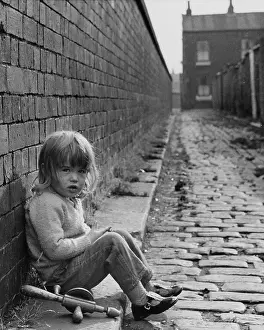 Cobblestones: Child sitting in an alleyway