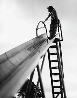 Child standing at the top of a playground slide
