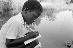Squatter: Child from a tented camp doing his homework on