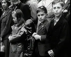 Raincoat: Several Children at the Front of a Crowd Near