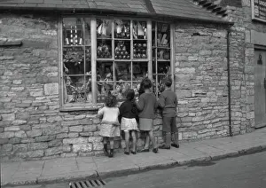 Longing: Four children gazing through shop window