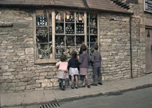 Longing: Four children gazing through shop window