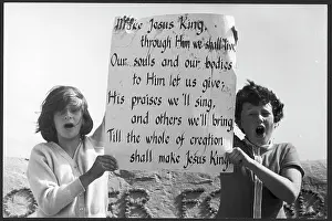 Maurice Ambler Collection: Children holding up hymn lyrics on a beach