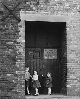 Structural: Three children in a large doorway, 1961