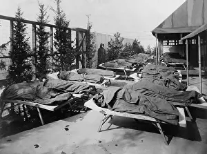 Cots: Children lie on cots, wrapped in blankets