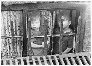 Slums: Children look out from a Limehouse basement