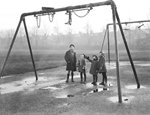 Puddles: Children looking up at tangled swings in a playground