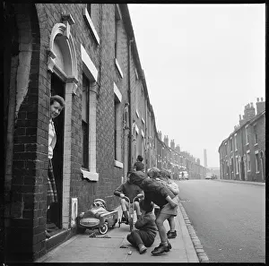 Deste: Children playing on the pavement outside a house