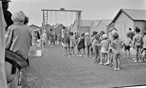 Berets: Children queueing up for a ride on the swings