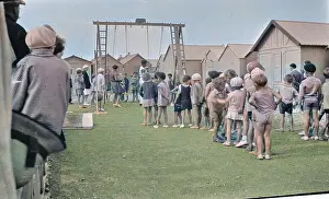 Berets: Children queueing up for a ride on the swings